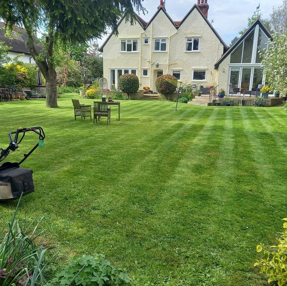 A freshly striped lawn behind a country house